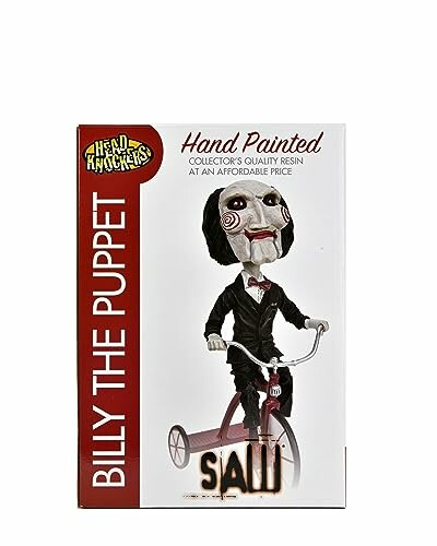 Billy the Puppet figure on a tricycle in a box.