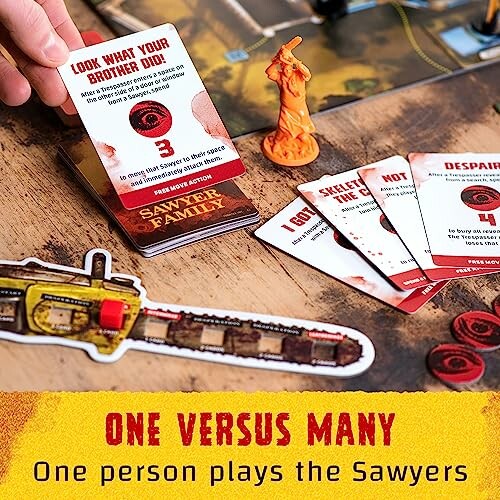 Board game setup with cards, a chainsaw token, and an orange figure.