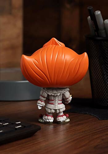 Funko Pop figure with orange hair on a desk.