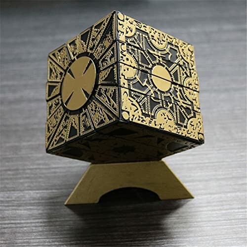 Intricate golden puzzle box on a stand