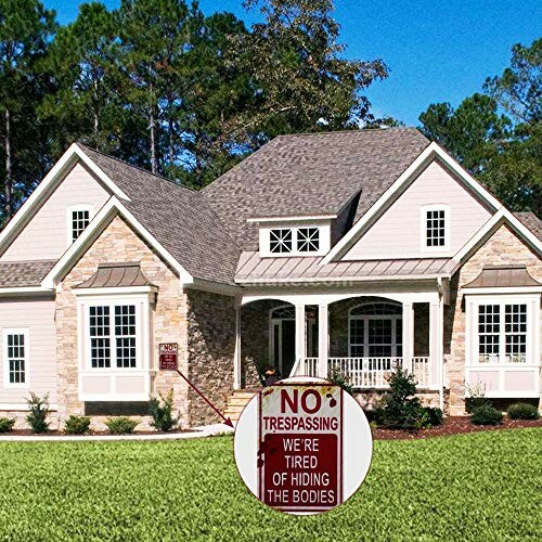 House with a humorous no trespassing sign on the lawn.