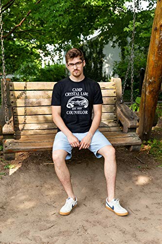 Man sitting on a wooden swing in a park.