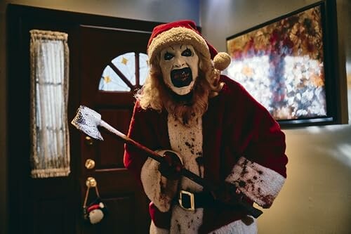 Person in a creepy Santa costume holding an axe indoors.